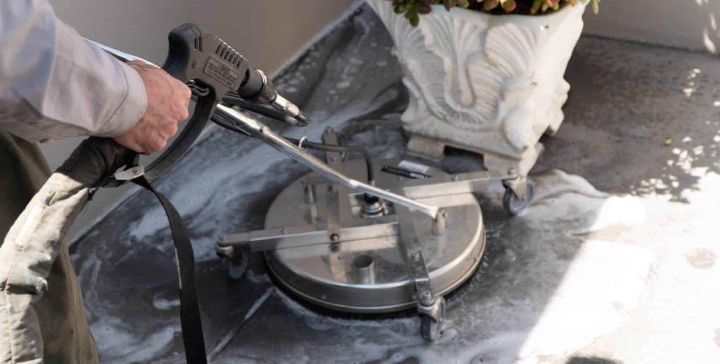 Close-up of surface cleaner removing dirt and grime from concrete floor