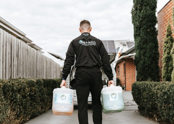 Refined Exterior Cleaning Facade washing service in progress, with technicians cleaning the exterior walls of a building using specialized equipment.